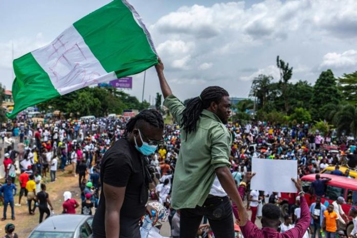 Un manifestant nigérian brandit le drapeau national lors d'une manifestation contre les violences policières, le 13 octobre 2020 à Lagos. afp.com - Benson Ibeabuchi