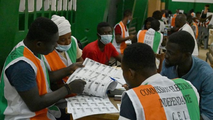 Des membres de la Commission électorale ivoirienne vérifient les listes de votants pendant le comptage des voix, le 31 octobre 2020 à Abidjan afp.com - Issouf SANOGO