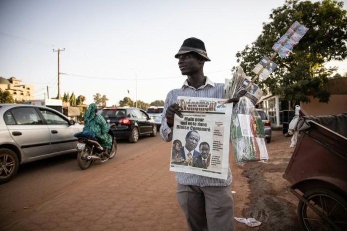 Un vendeur ambulant tient des journaux avec la photo de l'ancien président du Burkina Blaise Compaoré, à Ouagadougou le 22 novembre 2020 afp.com - OLYMPIA DE MAISMONT
