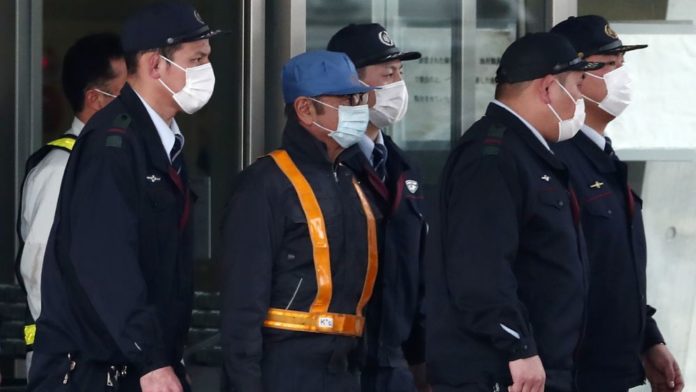 L'ancien patron de Renault Carlos Ghosn (c) est escorté à sa sortie de détention suite au versement d'une caution, à Tokyo, le 6 mars 2019 afp.com - Behrouz MEHRI