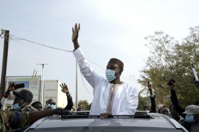 Ousmane Sonko, figure de l'opposition au Sénégal salue ses partisans le 3 mars 2021 à Dakar, sur le chemin vers le palais de justice, où il doit être interrogé pour des accusations de viols afp.com - Seyllou
