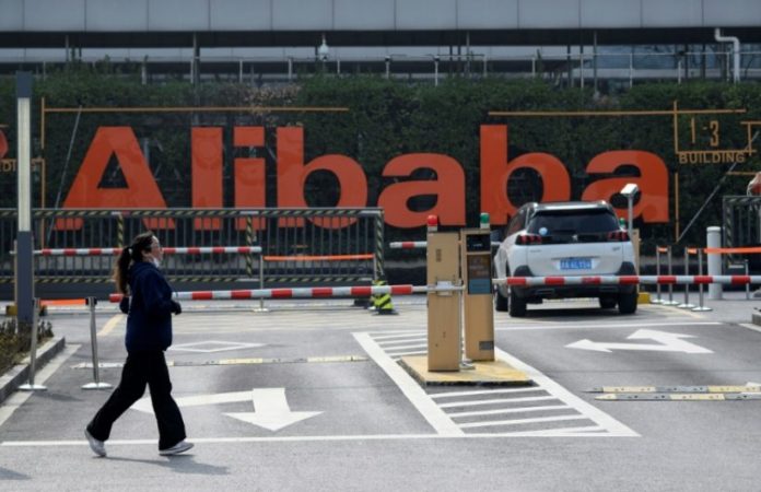 Une femme fait son jogging devant le siège d'Alibaba à Hangzou, à 175 kms de Shanghai, le 5 février 2020. Après avoir longtemps fermé les yeux sur leurs pratiques, la Chine veut ramener dans le rang ses géants technologiques à l'influence démesurée. afp.com - Noel CELIS