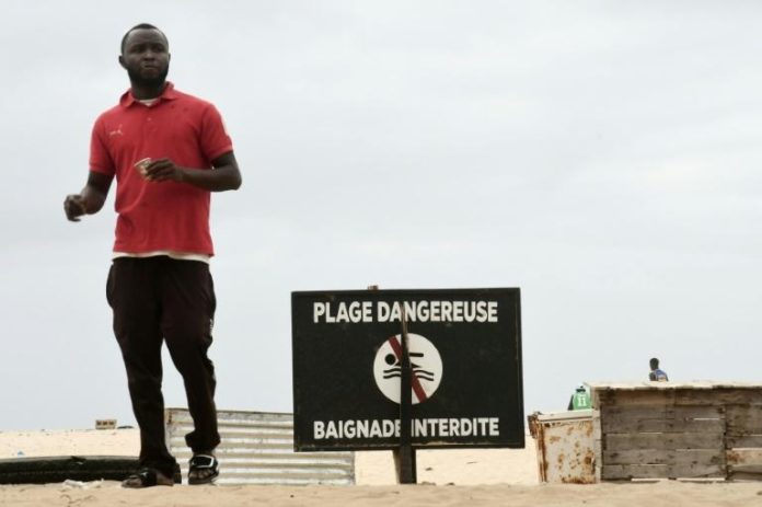 Un homme se promène sur une plage de Dakar où la baignade est interdite, le 4 juillet 2021. afp.com - Seyllou