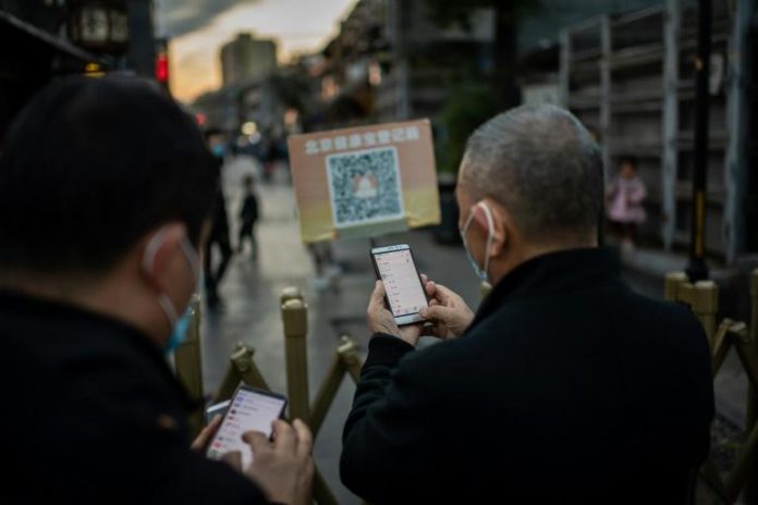 Dans les rues de Pékin, des habitants scannent leur QR code pour pénétrer dans un quartier de la ville, le 13 octobre 2020 afp.com - NICOLAS ASFOURI