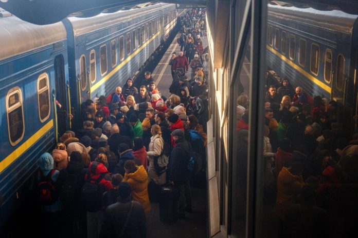 Des personnes fuyant l'Ukraine attendent d'embarquer dans un bus pour entrer en Pologne, au poste-frontière