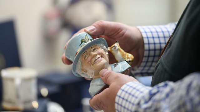 Simon Willis, propriétaire de Goviers, une entreprise spécialisée dans la fabrication de céramiques commémoratives, examine une figurine de la reine Elizabeth II créée pour ses 70 ans de règne, le 24 mars 2022 à Stoke-on-Trent, dans le centre de l'Angleterre afp.com - OLI SCARFF