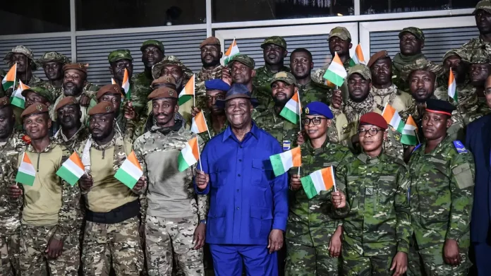 Le président ivoirien Alassane Ouattara (centre) pose avec les militaires ivoiriens détenus au Mali et venant d'être libérés, à l'aéroport d'Abidjan le 7 janvier 2023 afp.com - Sia KAMBOU