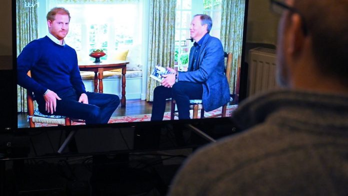 Un téléspectateur à Manchester, au Royaume-Uni, regarde une interview du prince Harry sur la chaîne britannique ITV1, le 8 janvier 2023 afp.com/Oli SCARFF