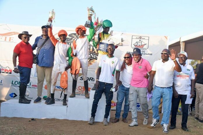 Des jockeys brandissent leurs trophées sur le podium du Grand Prix Jacqueline Ouégnin 2026 à Grand-Bassam